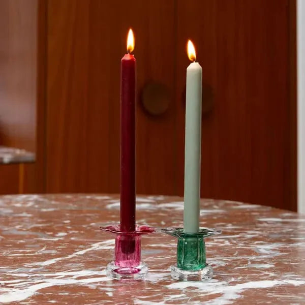 deux bougies sur des bougeoirs en verre soufflé en forme de pétales