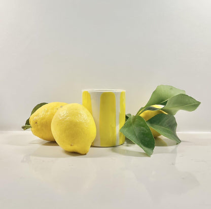 Bougie parfumée fragrance monoî coulée en France dans un élégant pot en céramique rayé jaune et blanche fabriqué en Espagne